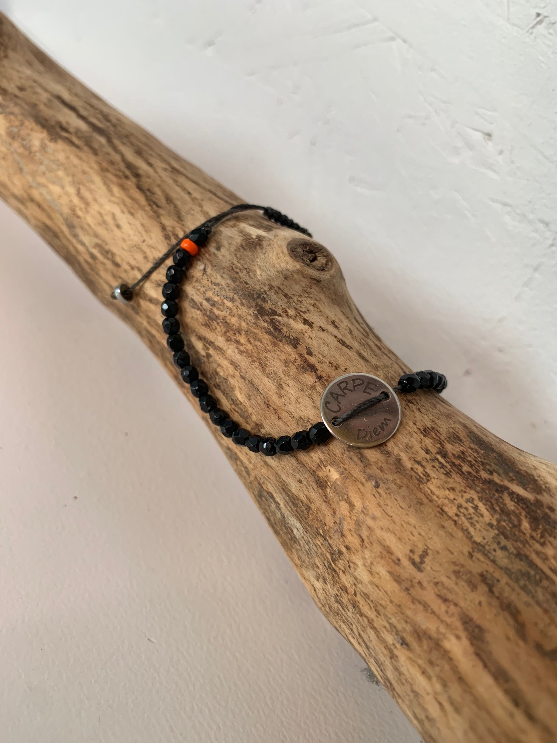 Détail du médaillon Carpe Diem sur bracelet noir