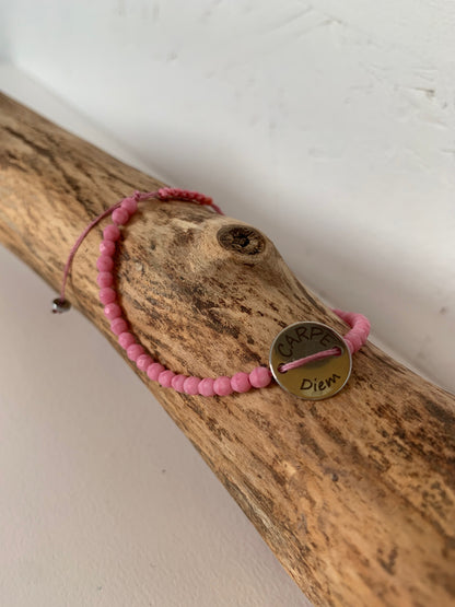 Détail du médaillon Carpe Diem sur bracelet rose 